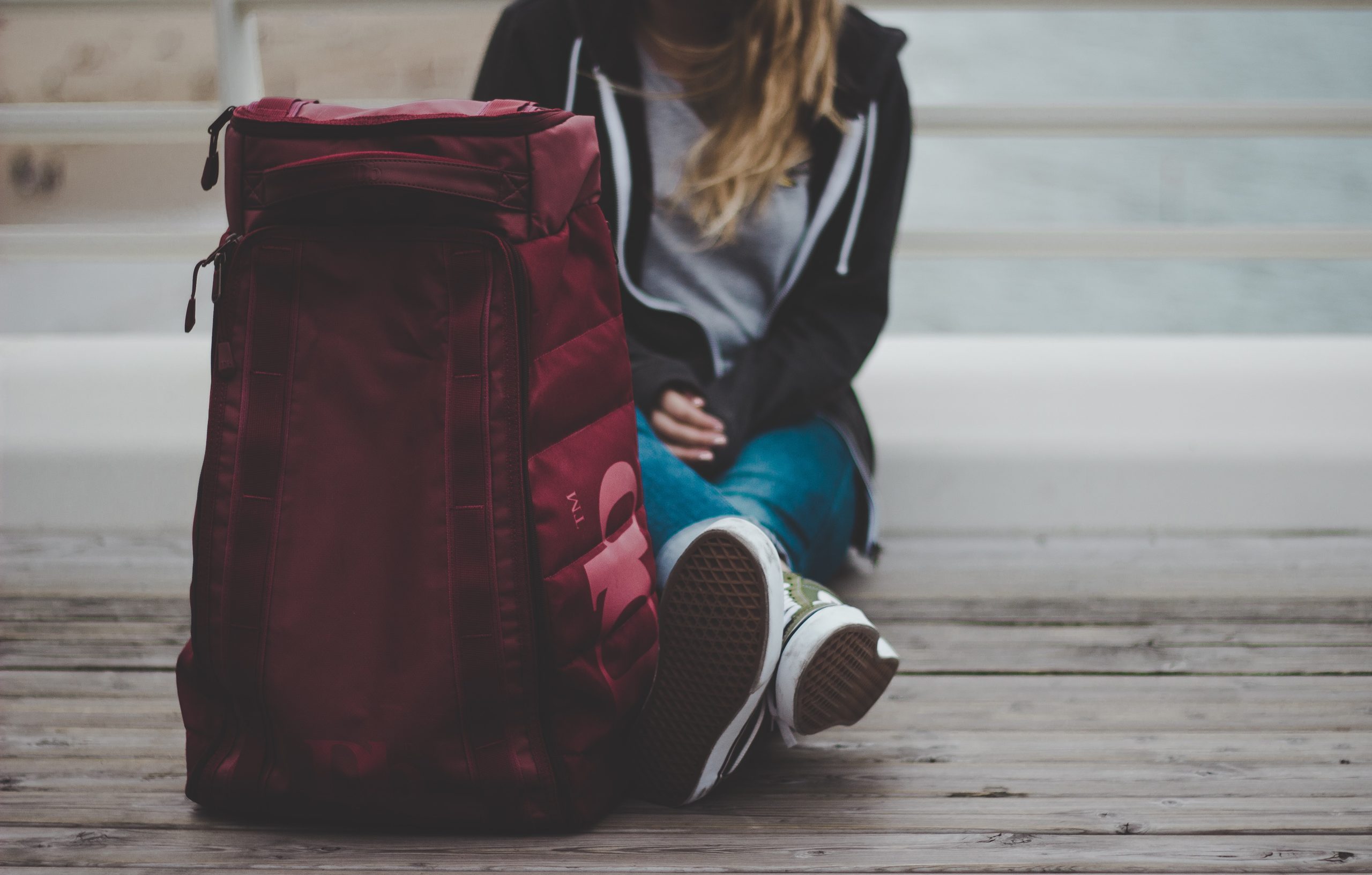 This is a maroon backpack with a large logo on the side.